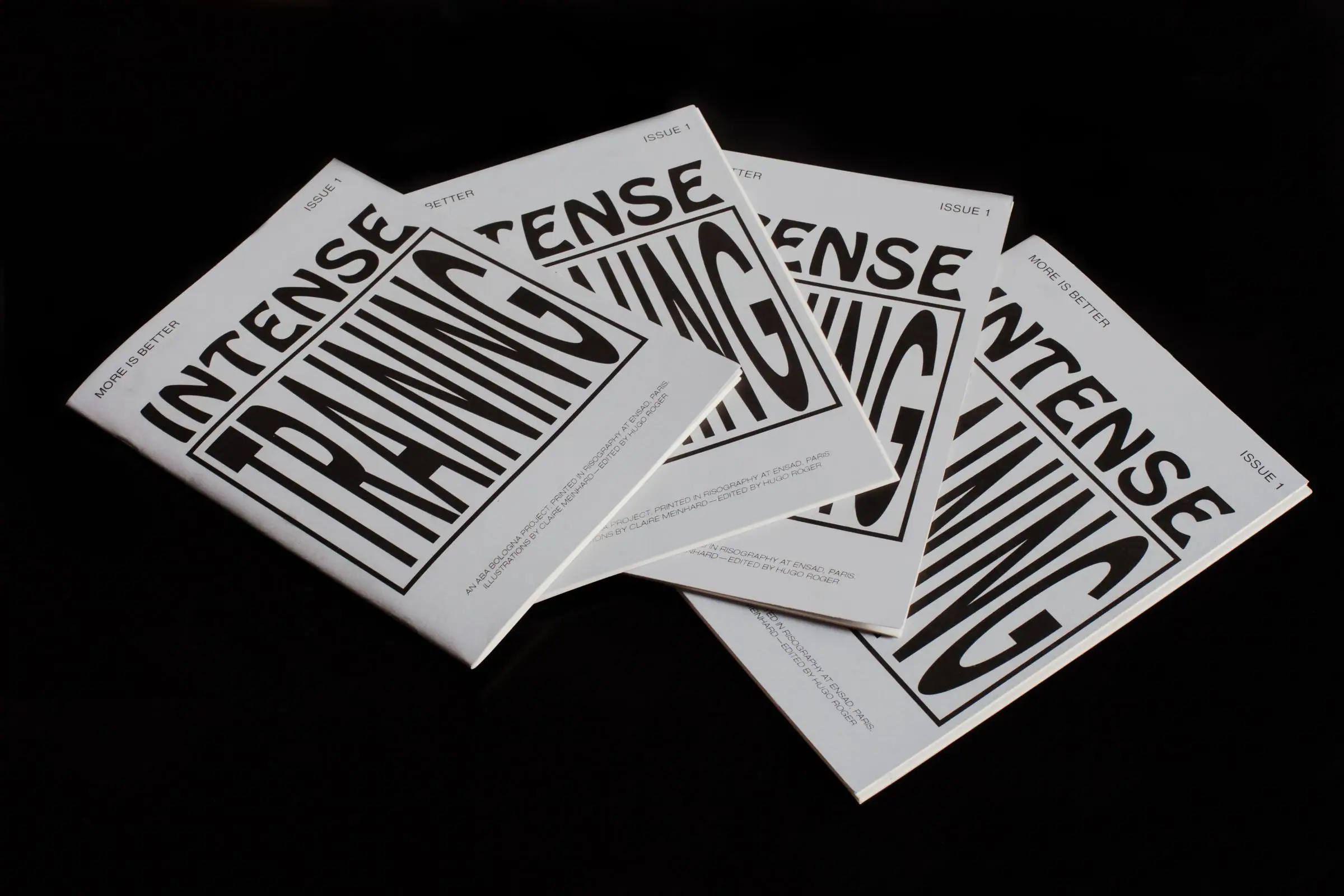 Four “INTENSE TRAINING” booklets fanned on a glossy black surface.