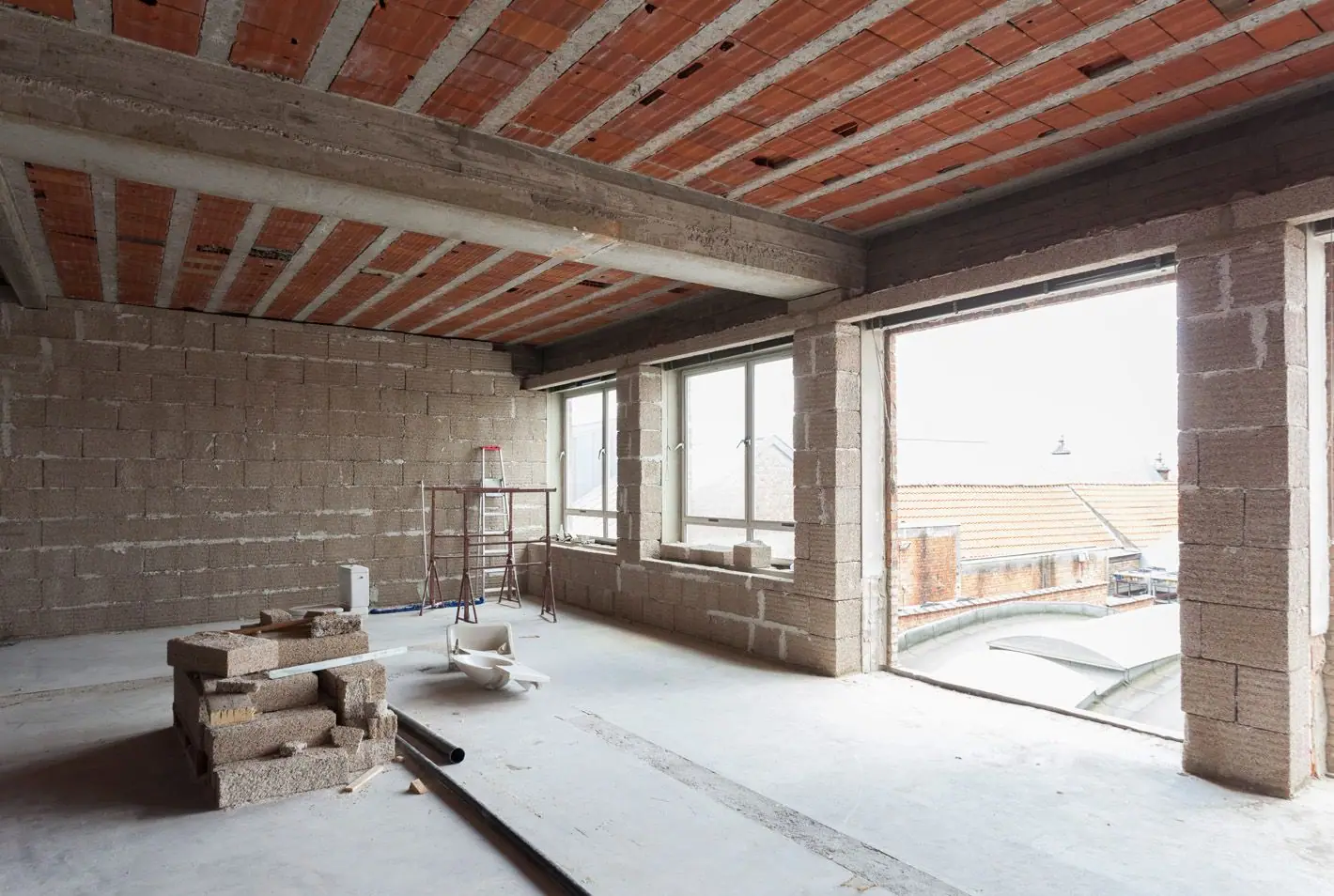 Unfinished room with concrete-block walls, ribbed tile ceiling and open windows.